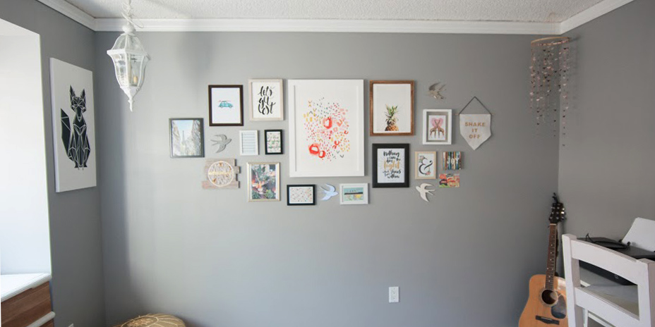 Newly painted wall with several pieces of framed artwork