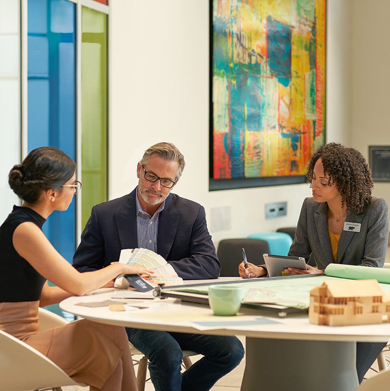Small image of 2 Pro painters painting the wooden railings of the exterior of an apartment block
