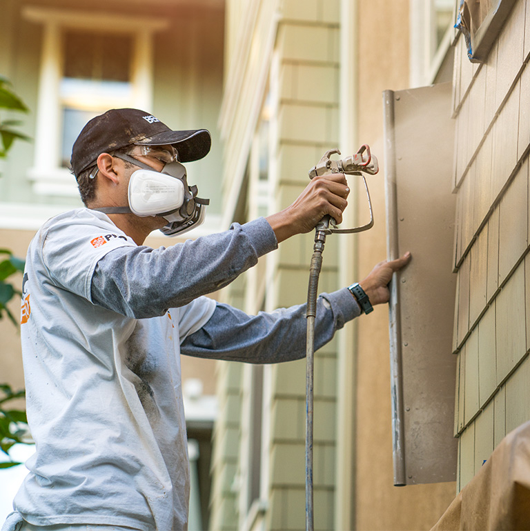 Small image of 2 Pro painters painting the wooden railings of the exterior of an apartment block