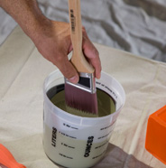 Dip brush into paint can.
