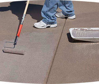 Person coating floor with paint and roller