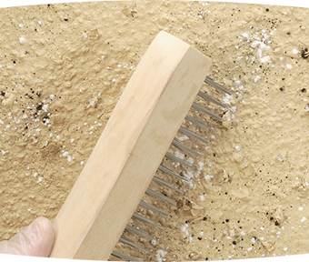 Person holding a comb like tool against surface