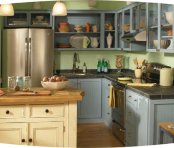 A kitchen with several cabinets, a refrigerator, and island table