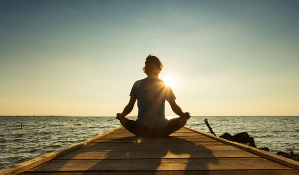 A person relaxing at the end of a dock.