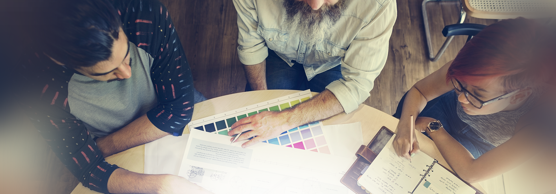 3 people sitting at a table discussing paint colors