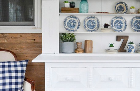 front of buffet with decor and dishes with chair next to it